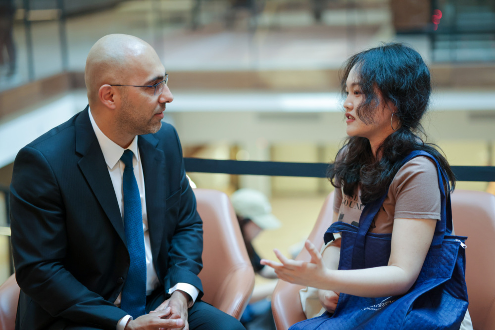 student and professor sitting down in chairs talking