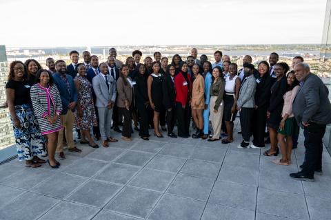 Large group of people standing outside on a terrace in a group all smiling for a photo