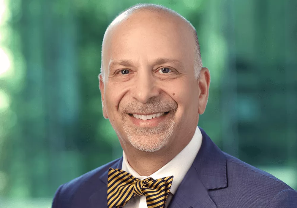 headshot of a person smiling with a suit and bowtie on headshot of a person smiling with a suit and bowtie on