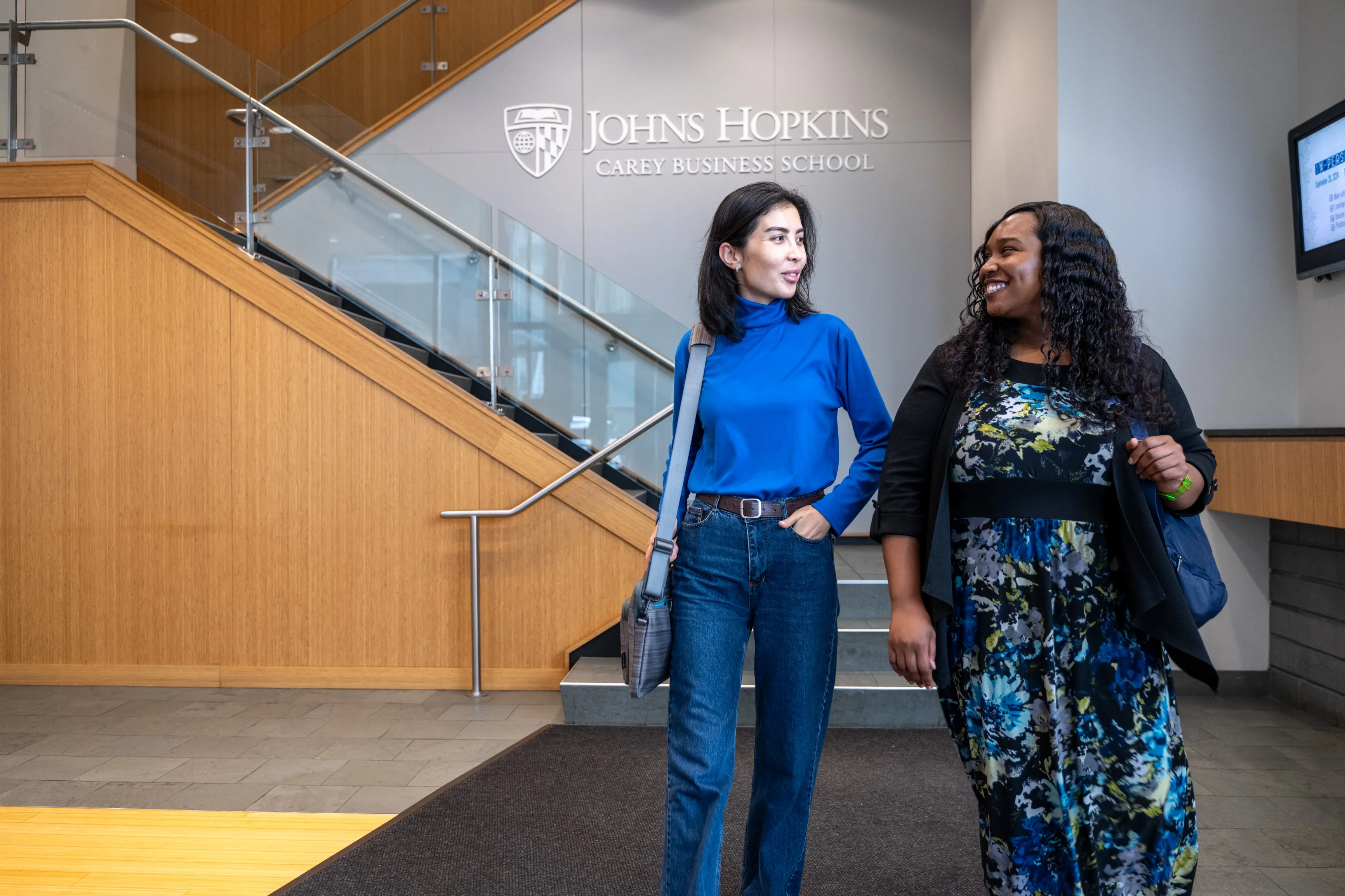 Two female students in the Carey Business School lobby