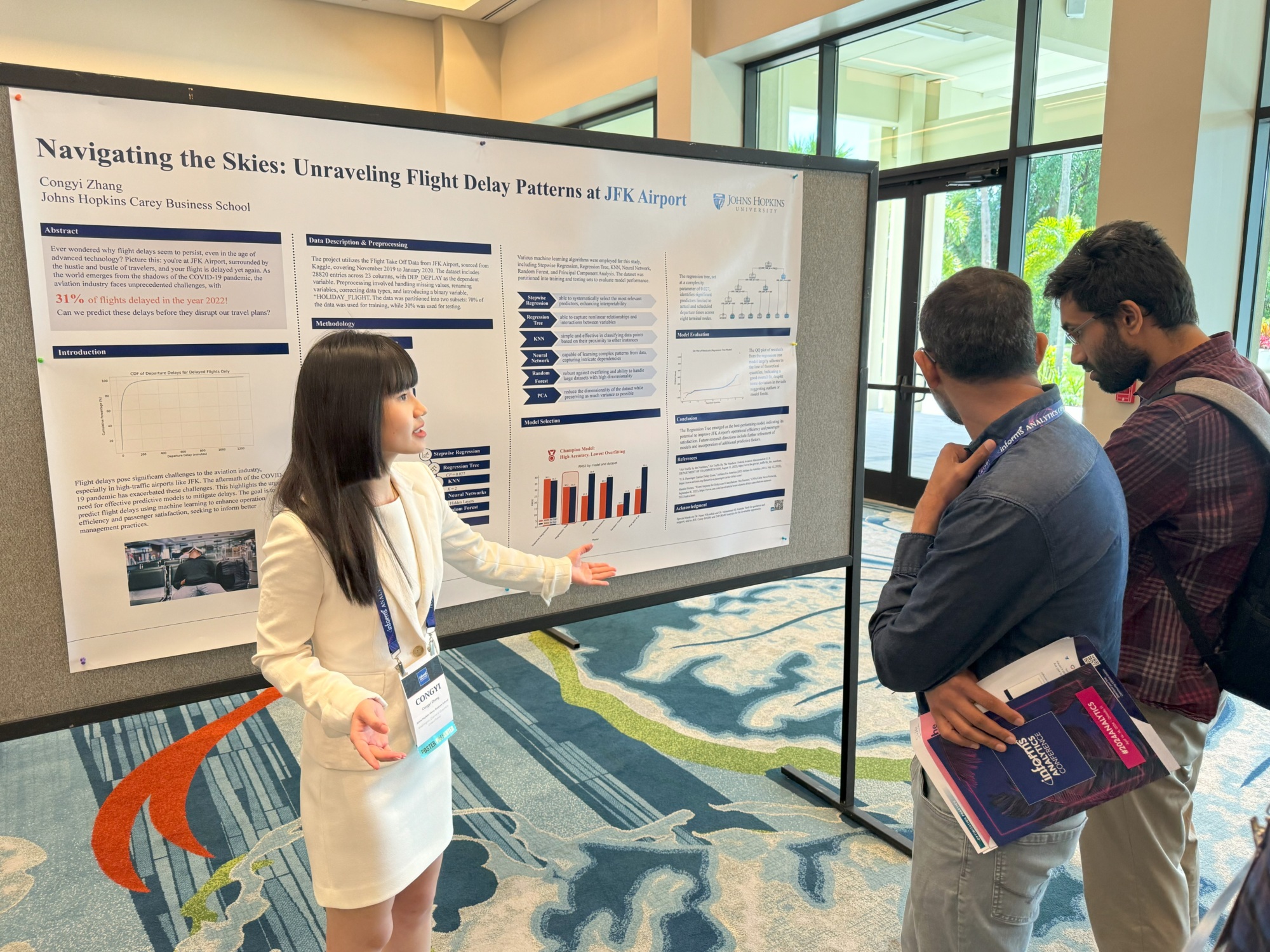 one person presenting poster to two people. all standing