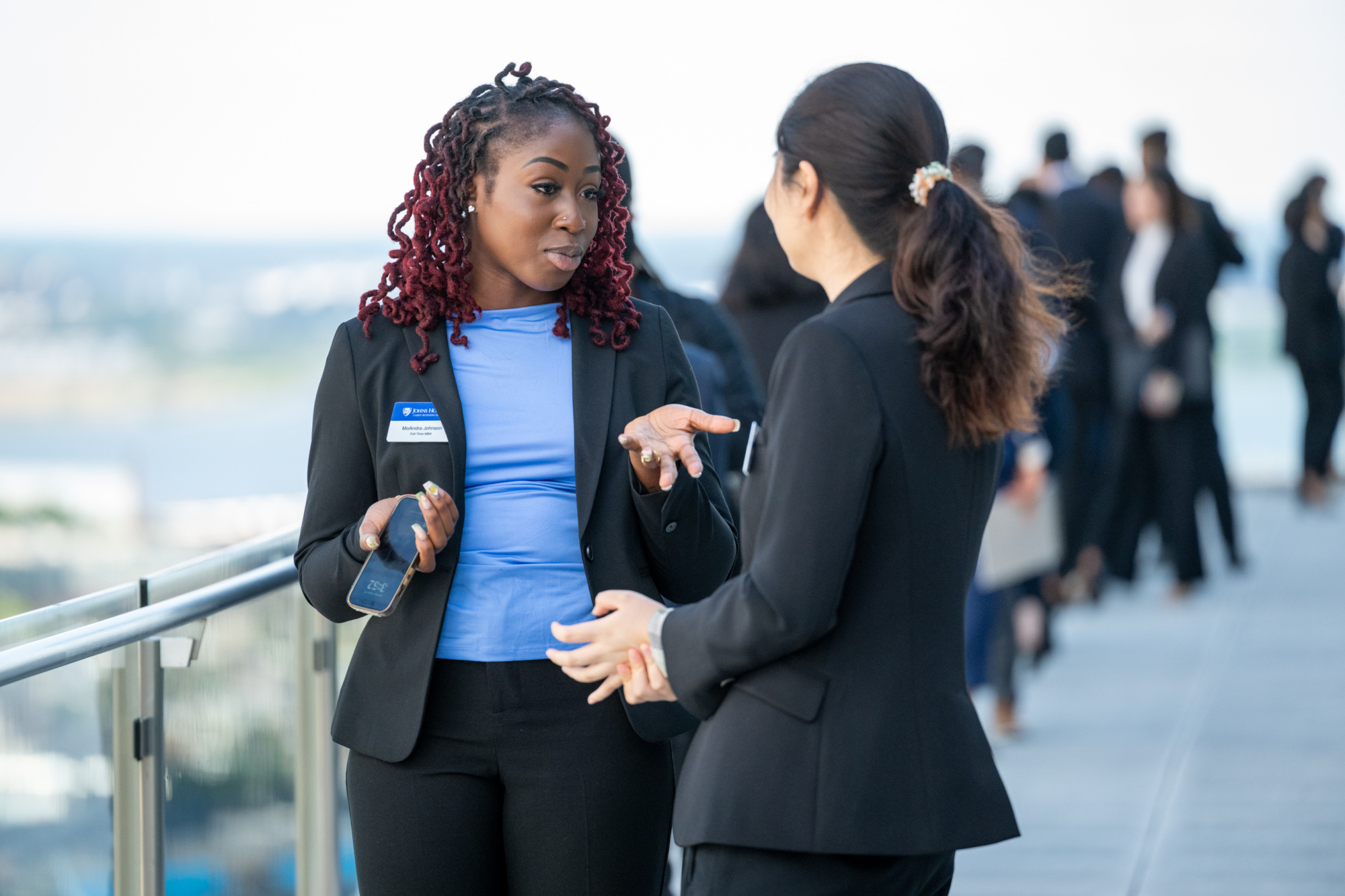 two people in business attire talking outside on a terrace