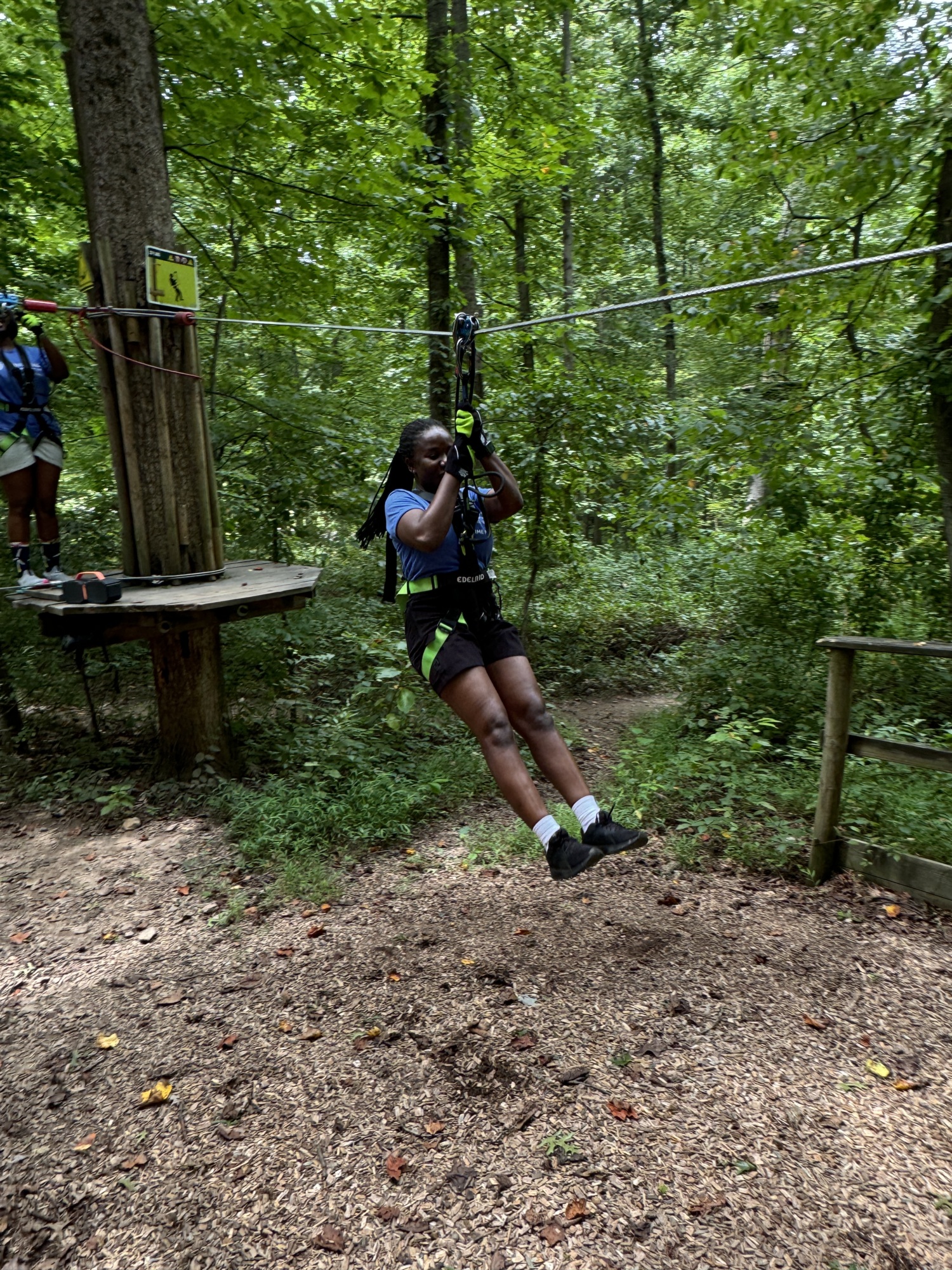 person on a ropes course ziplining