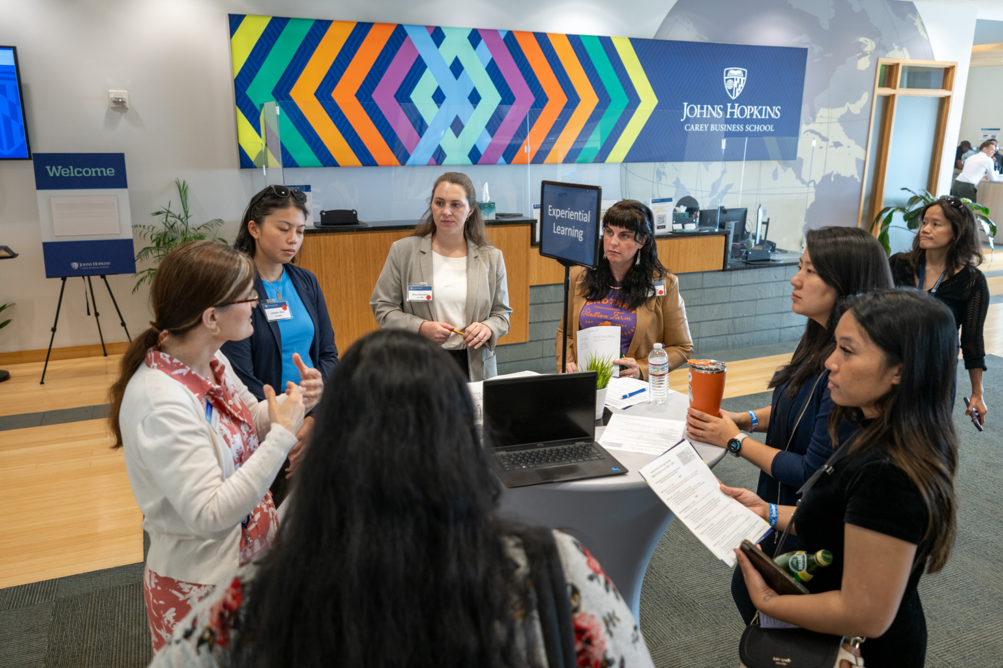 seven people standing in a circle all watching one person speak