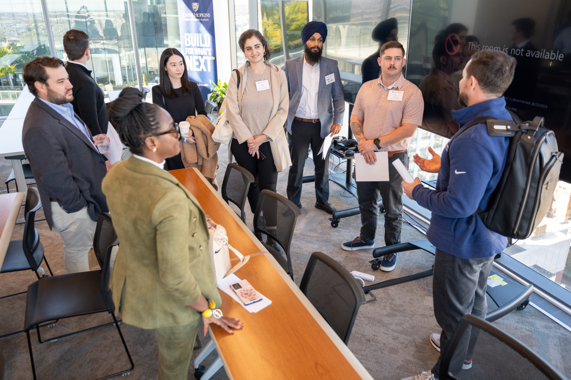 people standing at a long table speaking to each other