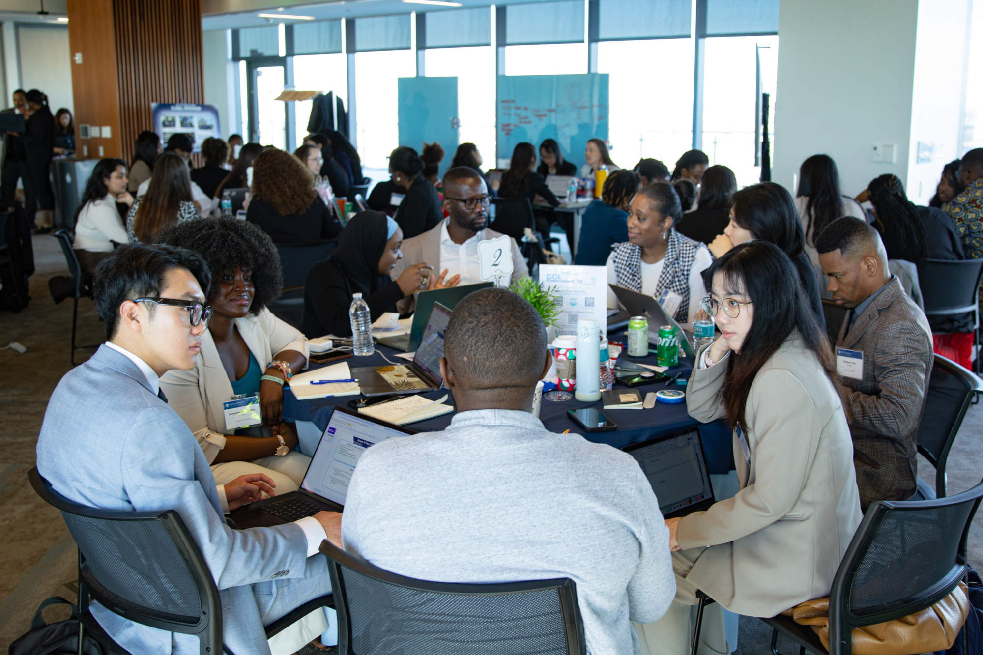 people sitting in a large conference room at tables talking to each other