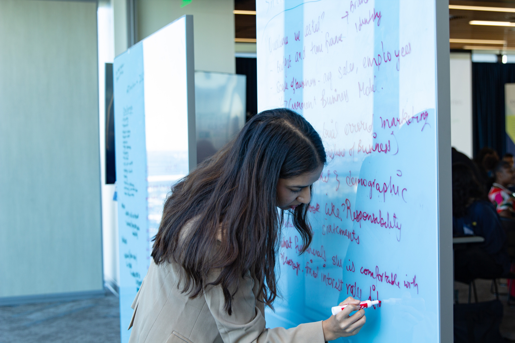 person writing on a whiteboard standing up